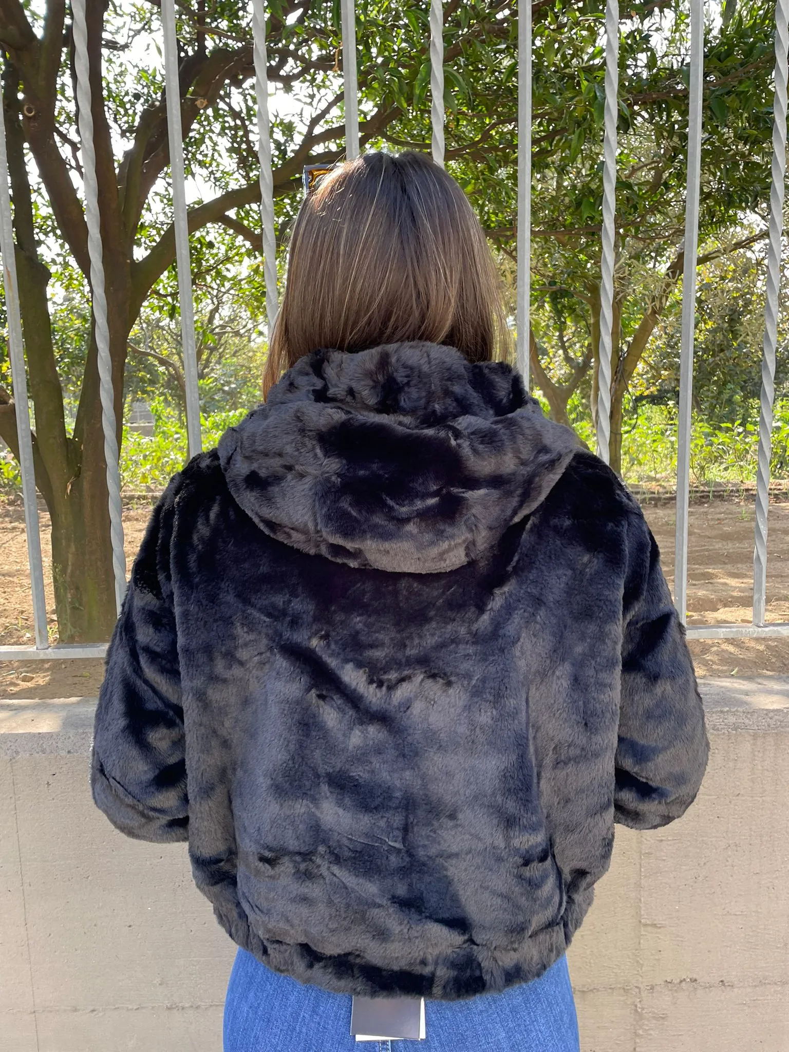 Pelliccia eco tinta unita con cappuccio e zip